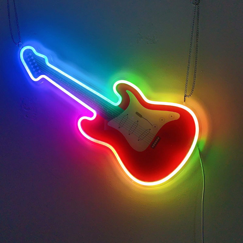 Colorful guitar-shaped neon sign glowing in vibrant RGB hues.