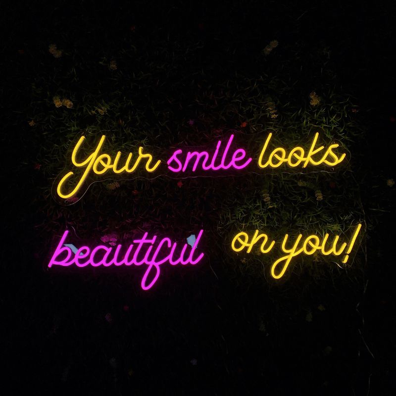 NEON wall decor from SELICOR with the inspiring message Your Smile Looks Beauty On You! in mesmerizing glowing letters enhancing room aesthetics